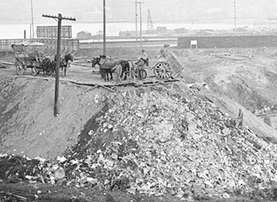 Garbage dump west of Westlake Avenue near South Lake Union, 1915. Looking northeast toward Capitol Hill. Horse-drawn wagons dumped garbage in low areas to create usable land alongside waterways. Courtesy Seattle Municipal Archives, Item No. 867. 