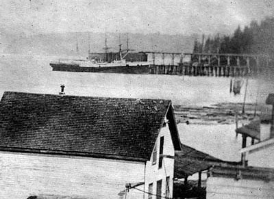 Pike Street coal bunker operated by the Seattle Coal & Transportation Co. in background of ca. 1876 view of the Seattle waterfront. Photo by Asahel Curtis. Courtesy UW Special Collections, UW7227.